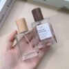 Two Glass Perfume Bottles Held in Hand Beech Walnut Caps