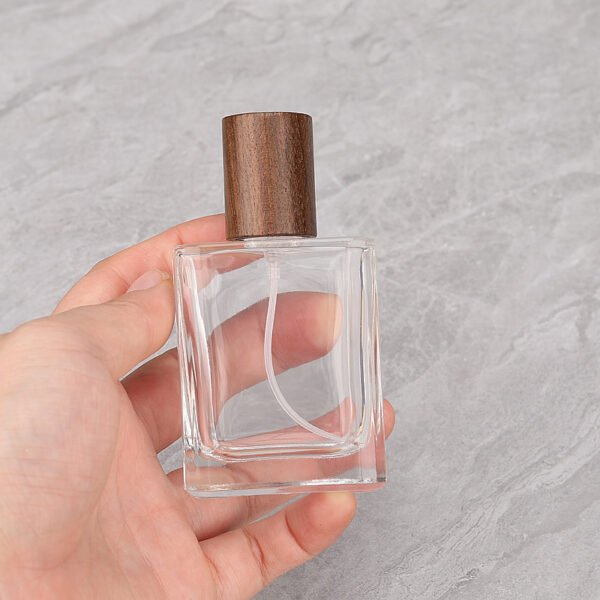 Hand Holding Square Glass Perfume Bottle Walnut Cap