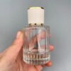 Ribbed Glass Bottle in Hand Grey Background
