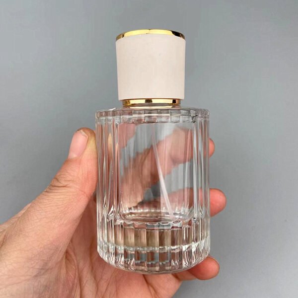 Ribbed Glass Bottle in Hand Grey Background