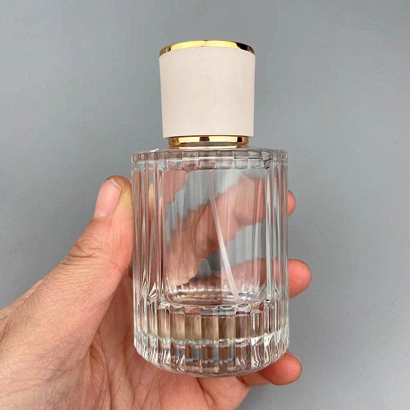 Ribbed Glass Bottle in Hand Grey Background